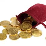 Goldmünzen verschiedener europäischer Ländern aus dem 19./20. Jahrhundert in einem Geldbeutel isoliert auf weißem Hintergrund