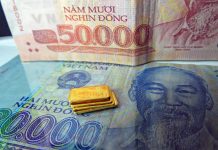 Kleine Goldbarren vor vietnamesischen Dong-Banknoten – Symbol für Goldmarkt-Öffnung