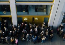 Kunden stehen Schlange vor dem Edelmetall-Händlel um Gold und Silber zu kaufen.