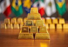 Goldreserven weltweit: Schwellenländer im Gold-Kaufrausch – massive Zukäufe gemeldet Goldbarren vor Länderflaggen – Schwellenländer kaufen massiv Gold