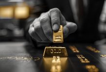 Hand eines Bankers, der einen Goldbarren bewegt – Symbol für Einfluss von Banken auf den Goldpreis