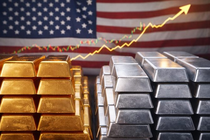 Gold- und Silberbarren vor US-Flagge mit steigendem Kursverlauf
