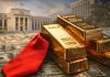 Goldbarren vor US-Dollar-Banknoten und Fed-Gebäude