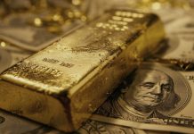 Goldbarren auf US-Dollar-Banknoten – Dollar-Schwäche stützt den Goldpreis