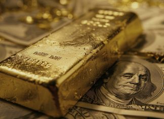 Goldbarren auf US-Dollar-Banknoten – Dollar-Schwäche stützt den Goldpreis